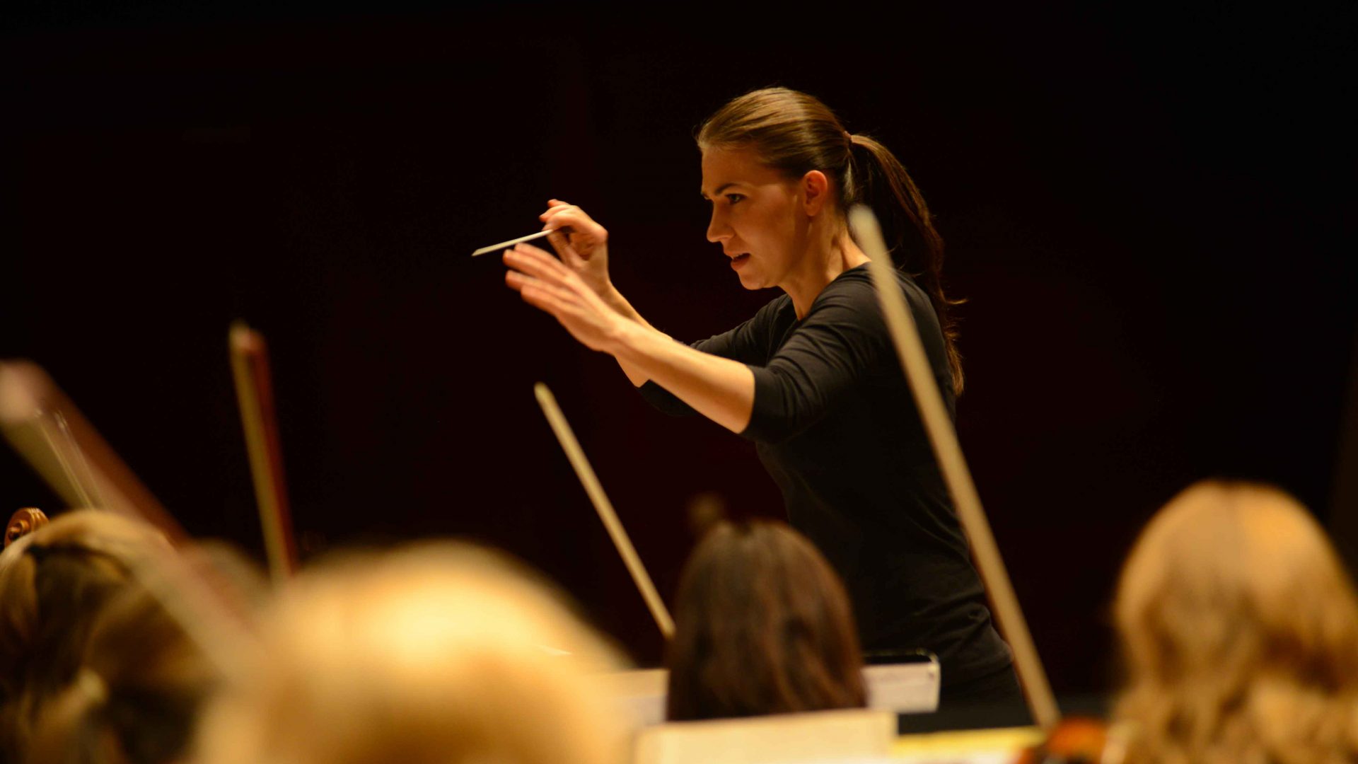 Young Conductor in Association Marta Gardolińska conducts the orchestra with an intense expression