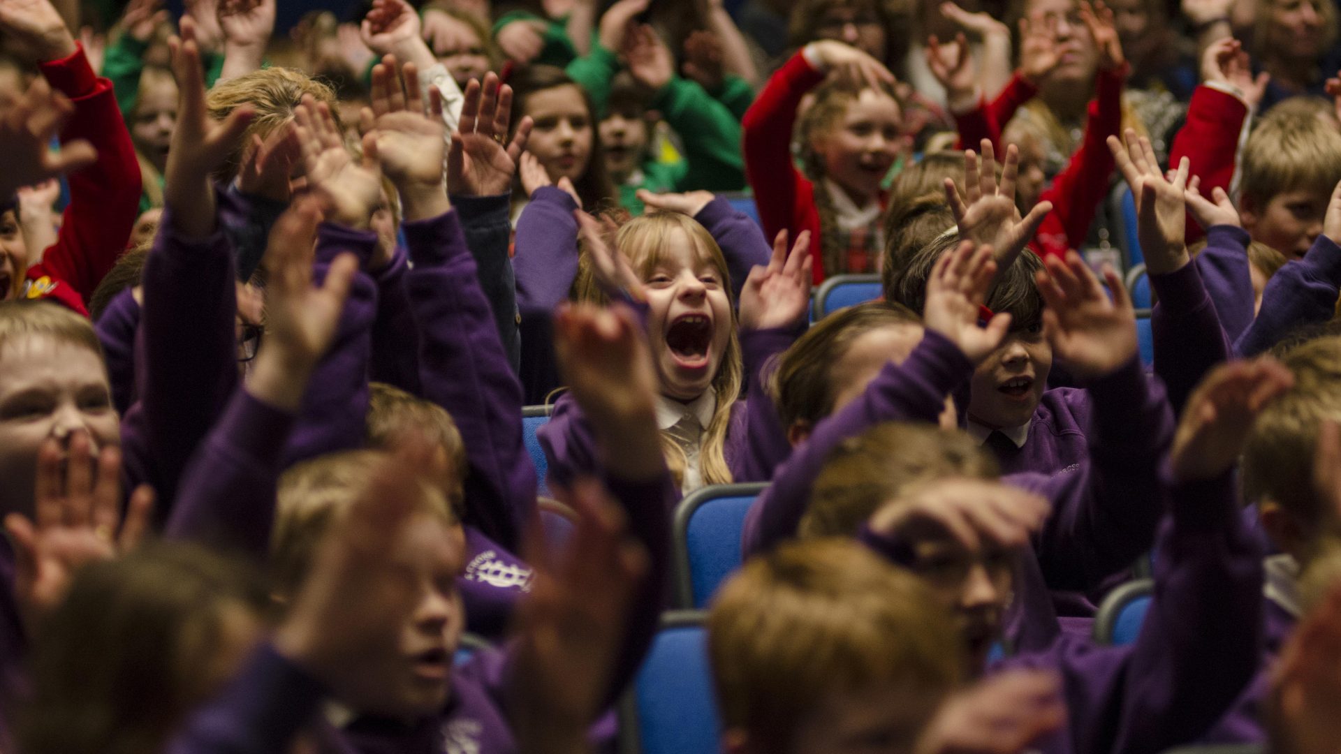 BSO School concerts - Kids in purple attire seated in an auditorium.