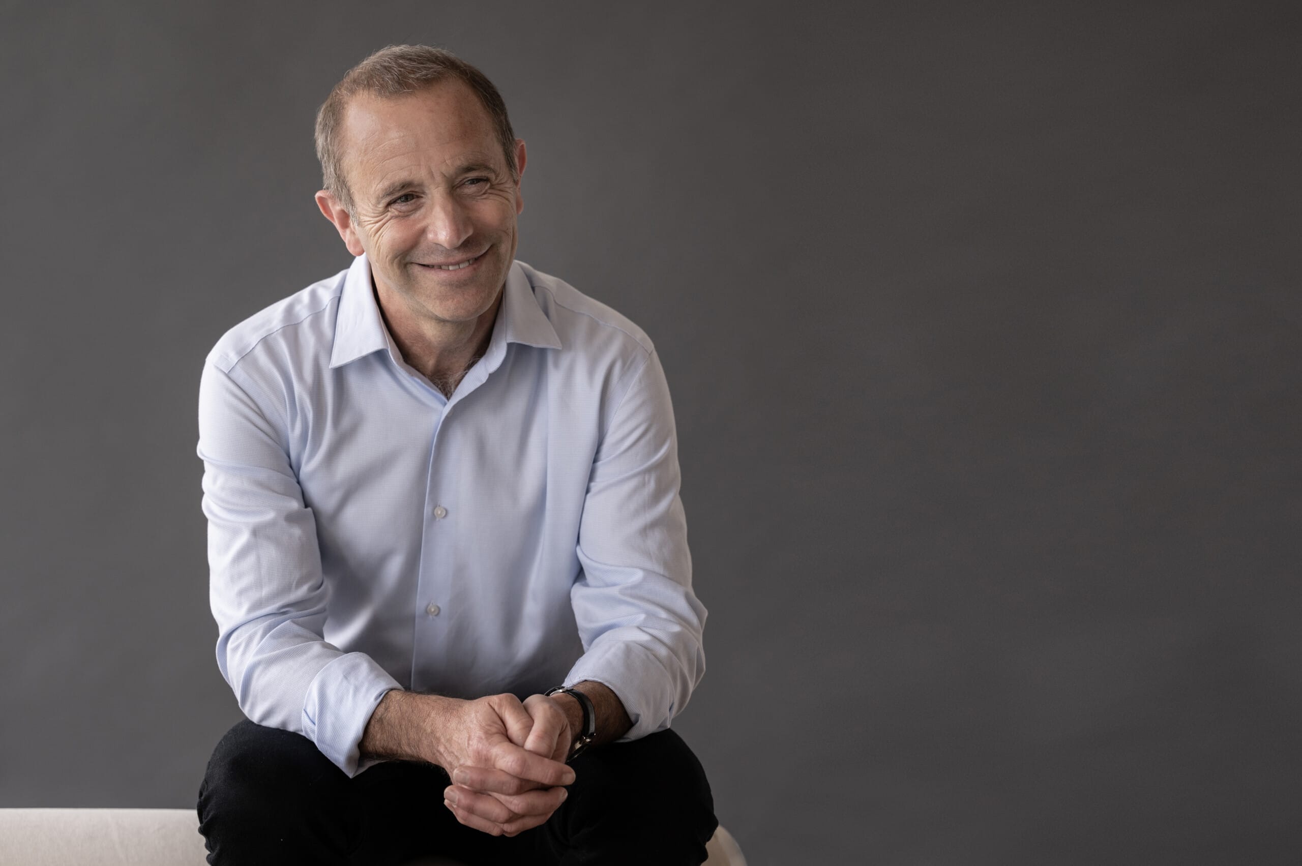 Seated man smiling and looking to the side