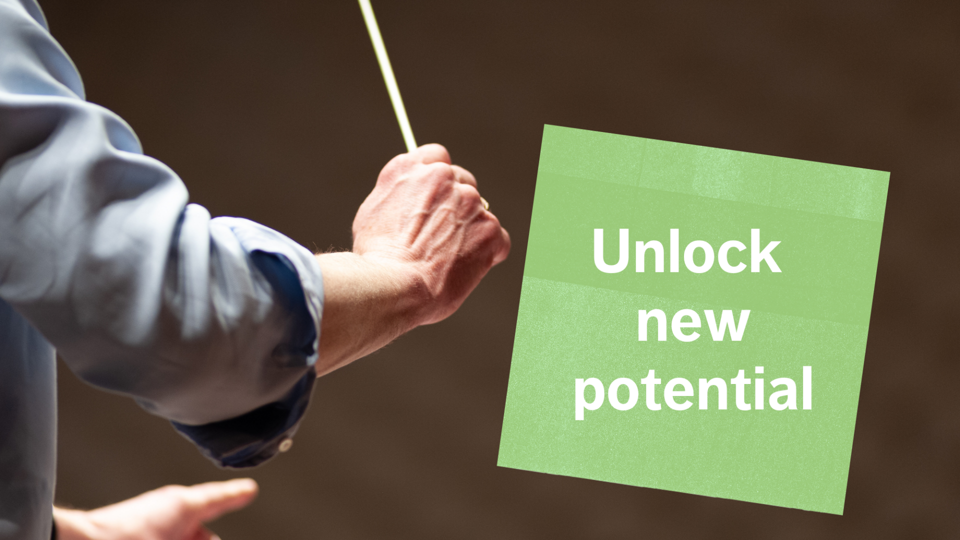 The right arm of a conductor holding a baton, with a green square next to it reading " Unlock your potential".