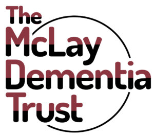Logo for the McLay Dementia Trust, with the text written in letters with a red to black gradient, and a circle around the edge.