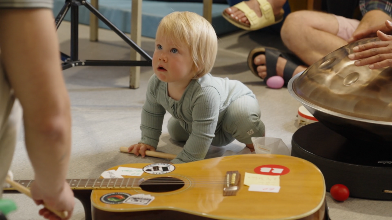 Young patient explores instruments as musicians play for him
