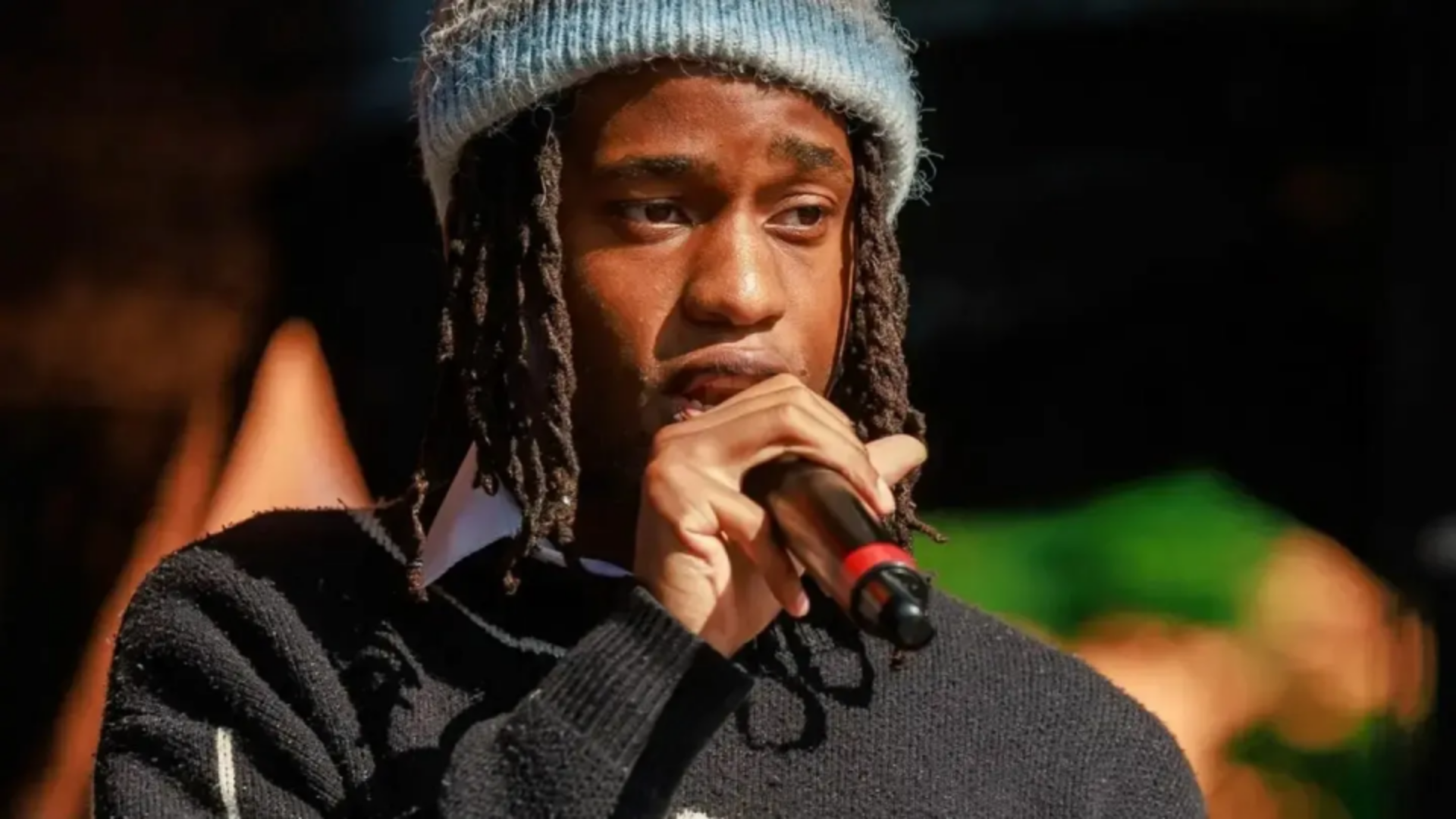 Spoken word artist, Baby Panna talks into a microphone