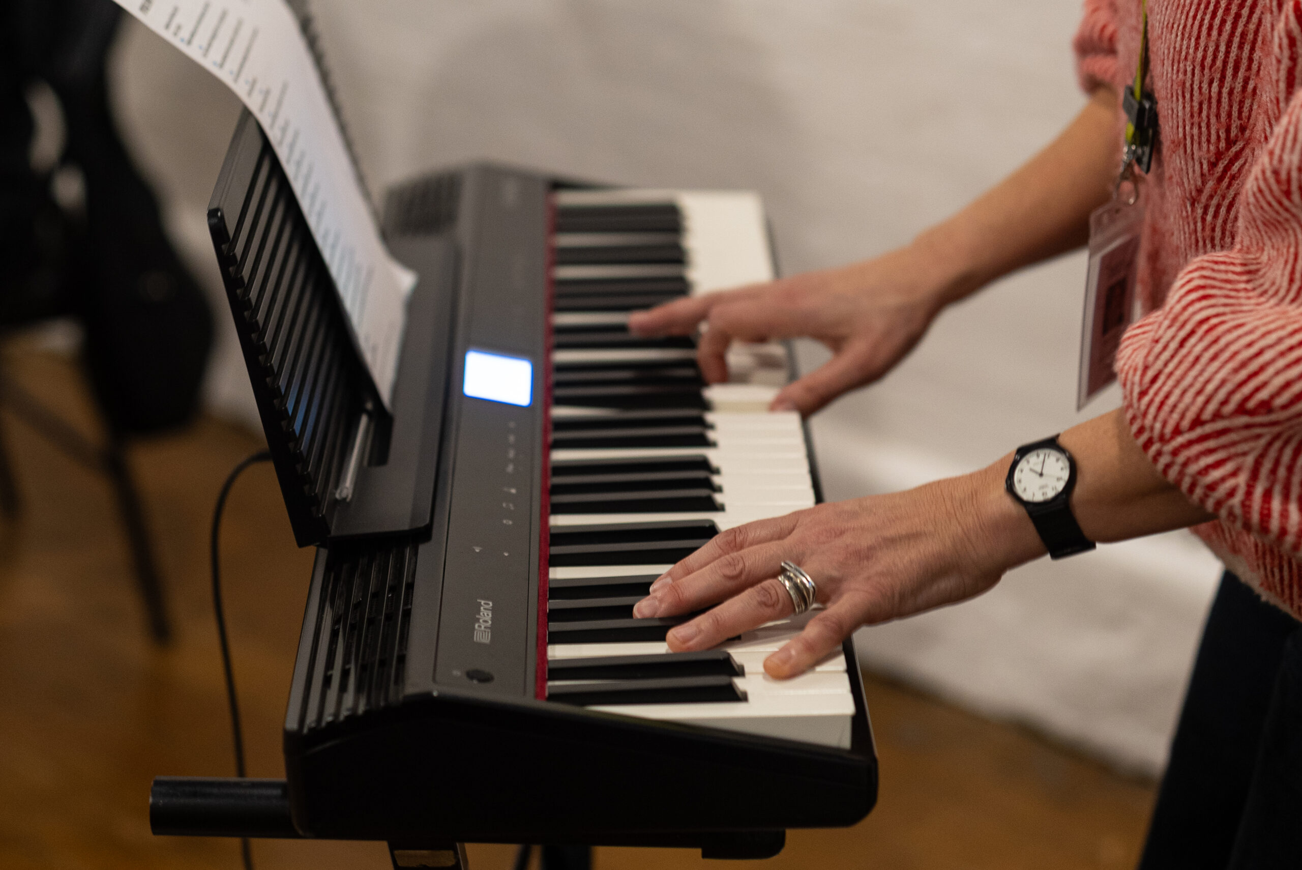 A person stands up to play keyboard in a local community group