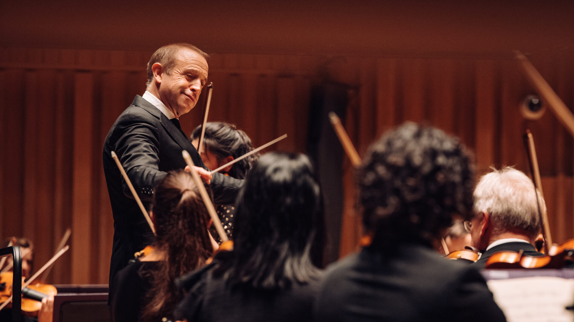 Conductor mid performance directing musicians on stage