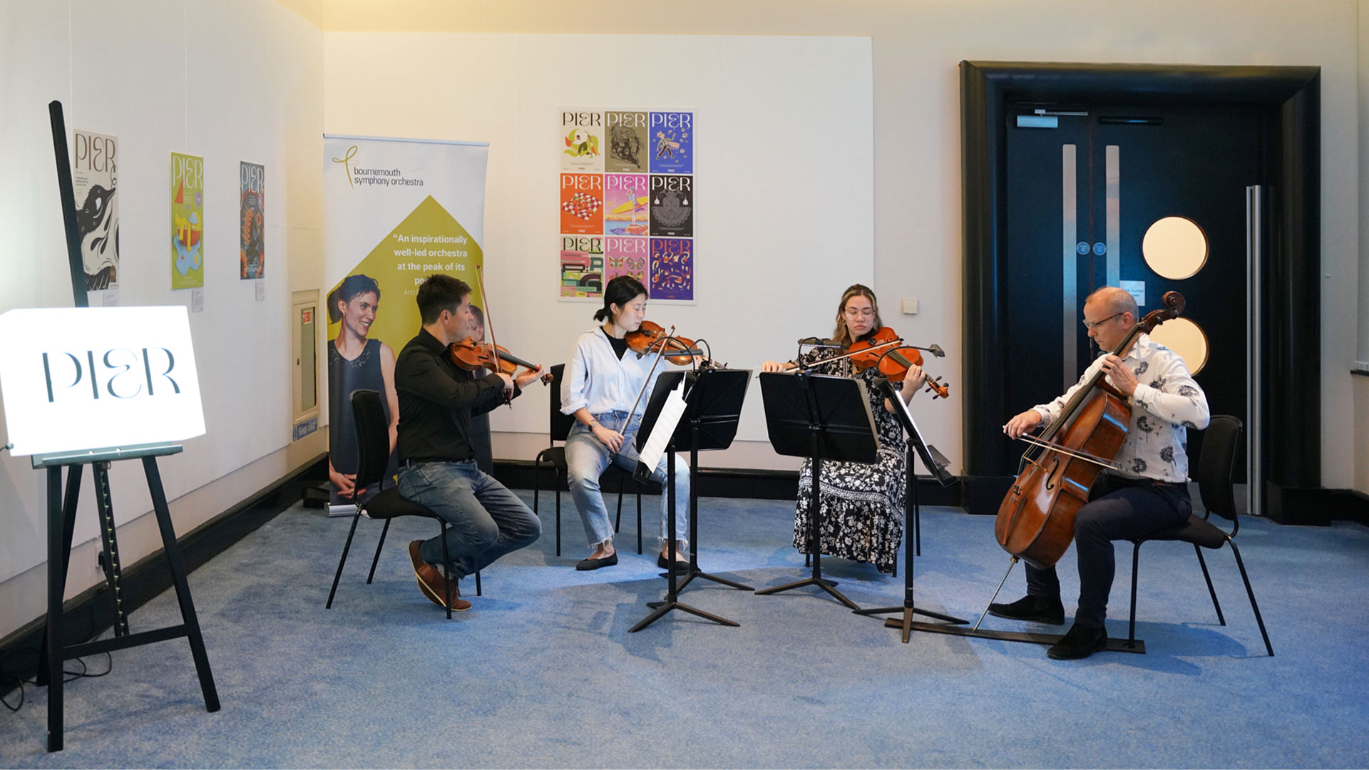 four musicians perform a string quartet in a gallery style space